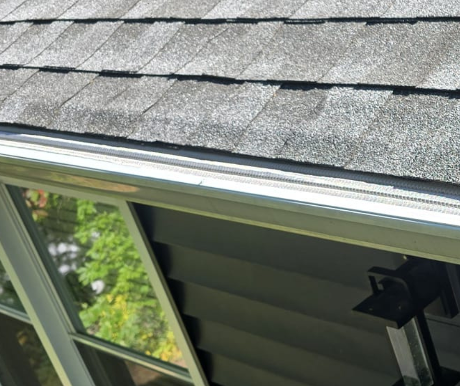 gutter guard installed on the gutters of a home with black shingles on roof